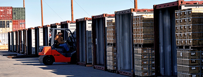 Photo of Tooele Army Depot worker picking and moving pallets of ammunition